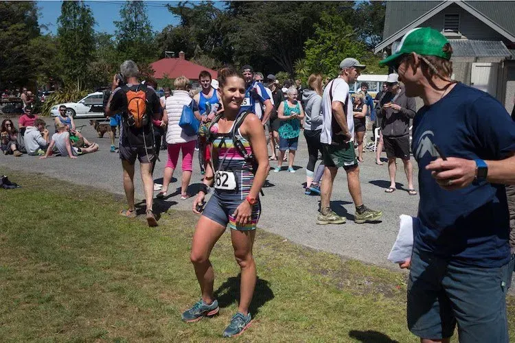 A woman with the number 27 on her shirt is standing in front of a crowd of people.