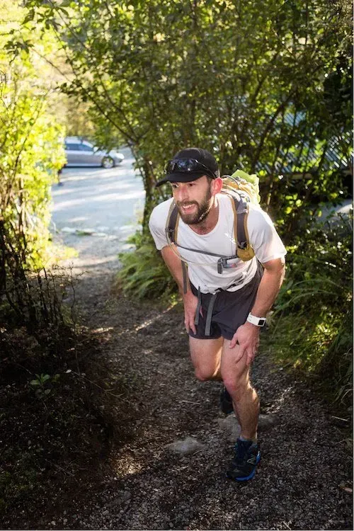 A man is running down a path in the woods.