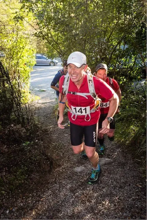 A group of people are running down a trail.