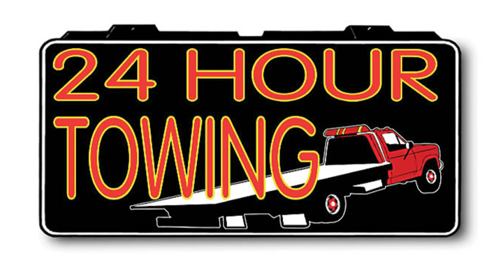 A 24 hour towing sign with a truck on it.