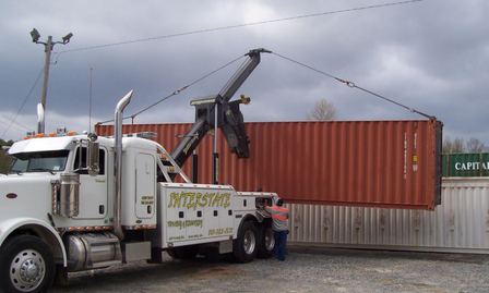 A white tow truck with interstate written on the side