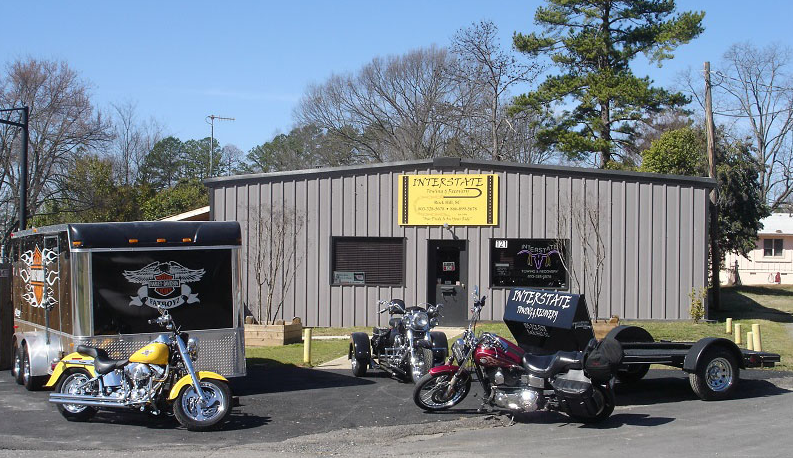 Several motorcycles are parked in front of a building that says ' harley davidson ' on it