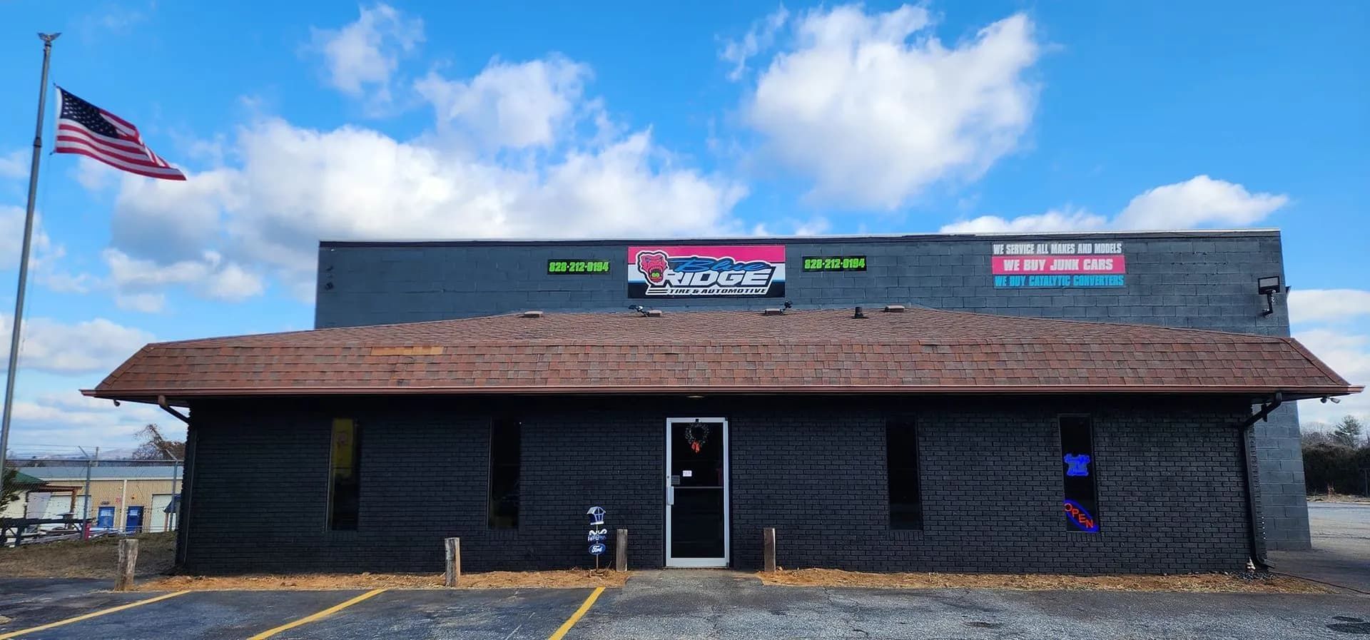 A single-story, dark gray building with a brown shingled roof.