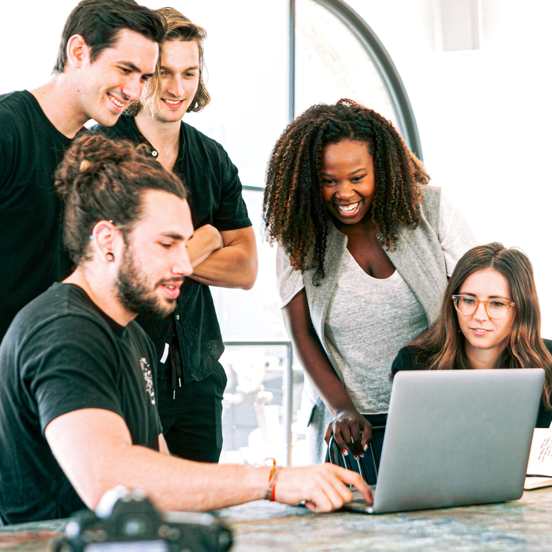 A group of people are looking at a laptop computer.