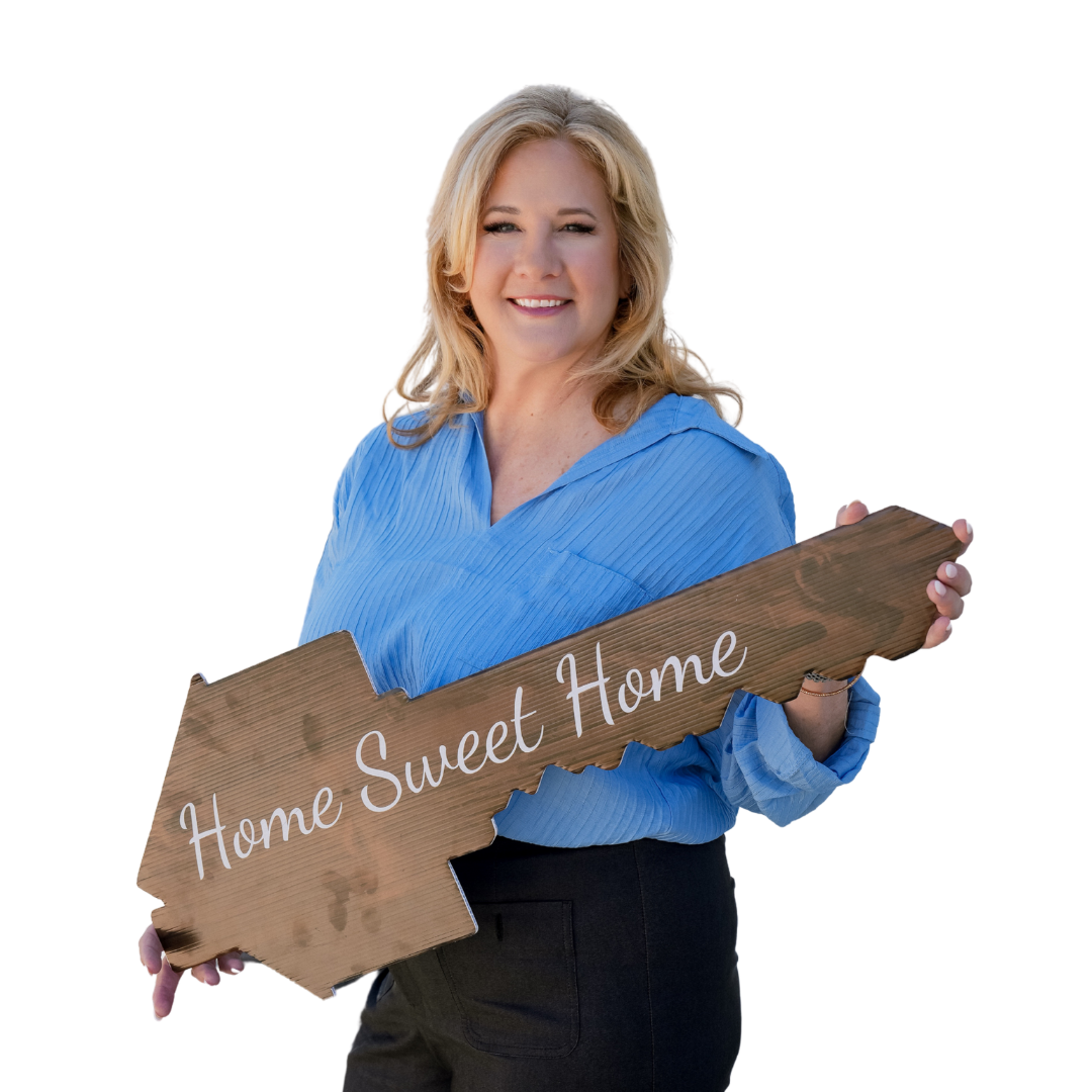 A woman is holding a large wooden key that says home sweet home.