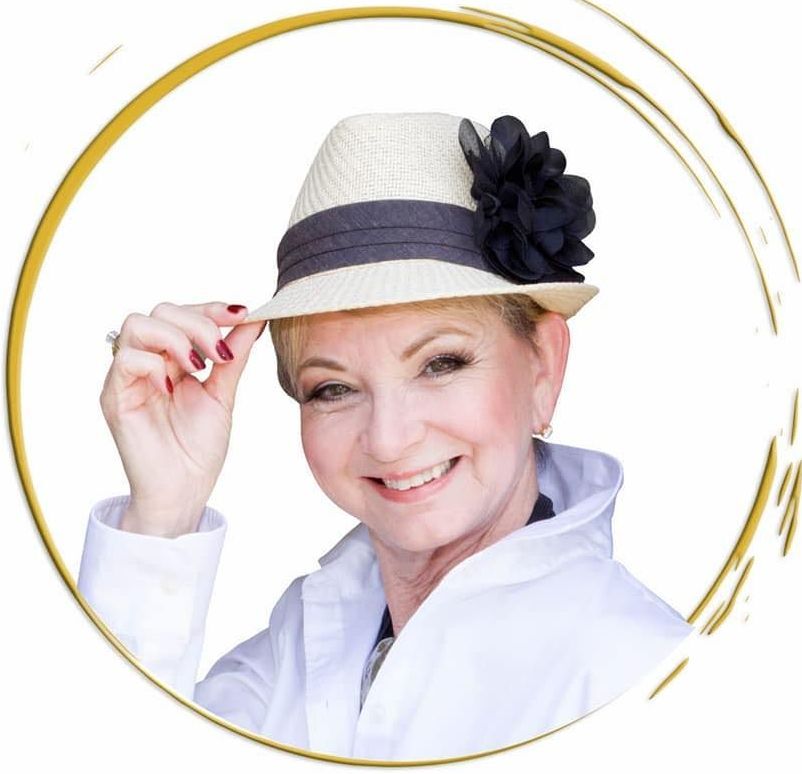 A woman wearing a hat with a black flower on it