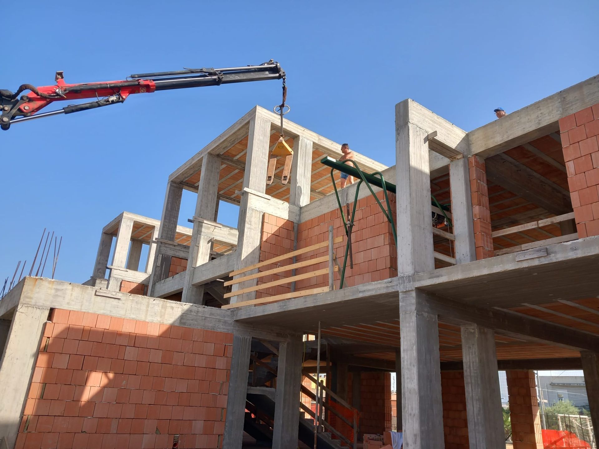 Villa bianca con tetto in terracotta, balcone e uliveto, con vista sul mare.