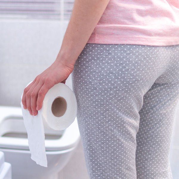 Woman with Constipation holding toilet paper