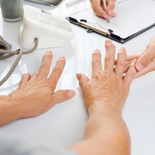 Woman with Rheumatoid Arthritis showing her hands to her doctor