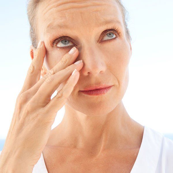 Woman rubbing her dry eyes from Sjogren's Syndrome
