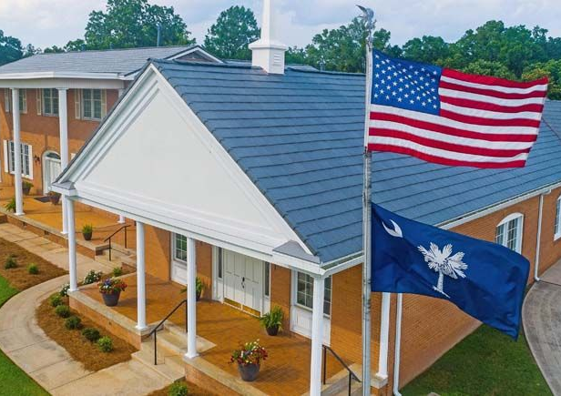 Wooden boardwalk leads to a gazebo over a marsh at sunrise.