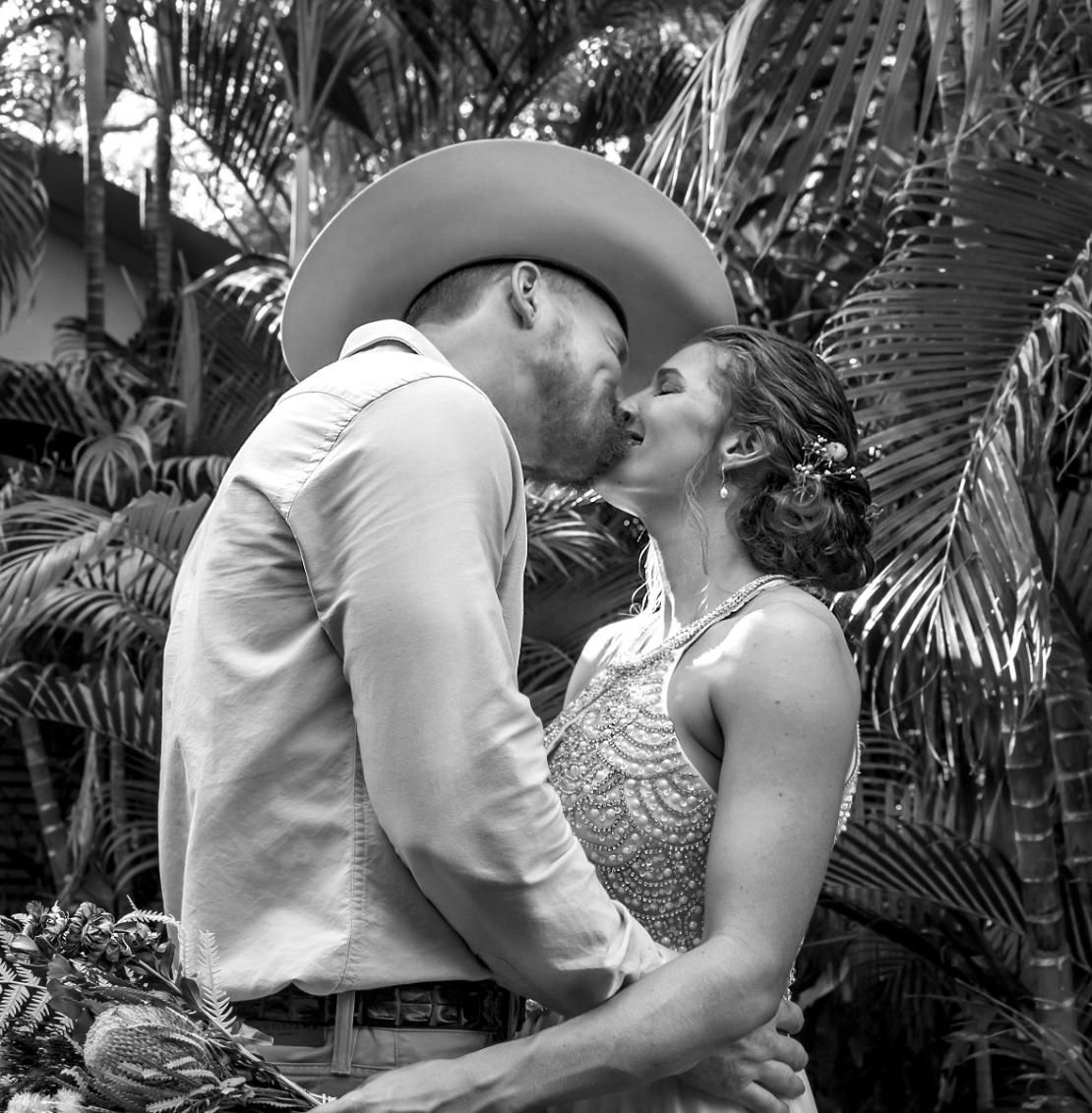 A Bride and Groom Kissing in front of Palm Trees — Photography in Darwin, NT