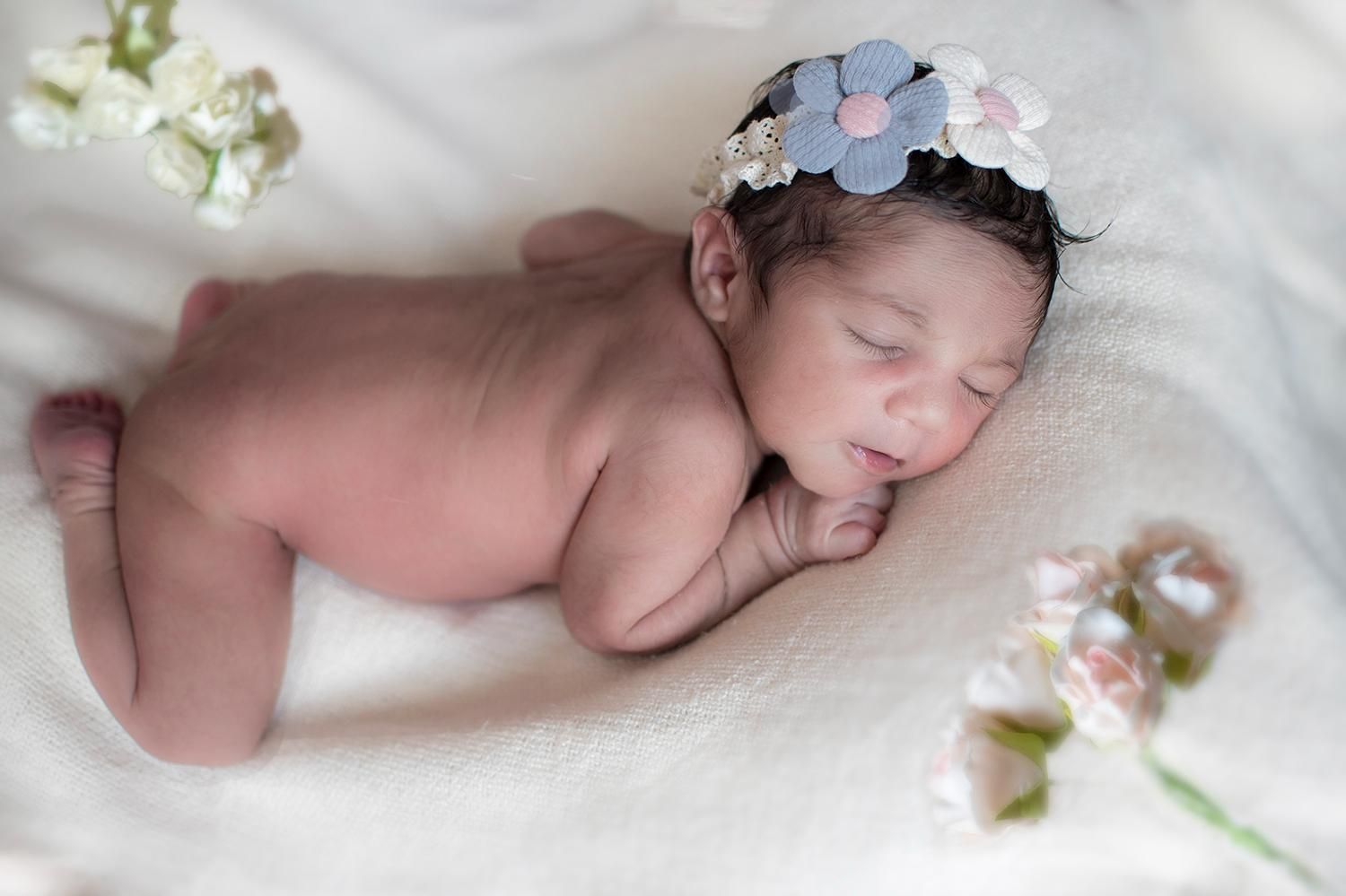 A Newborn Baby Wearing a Headband with Flowers on it — Photography in Darwin, NT