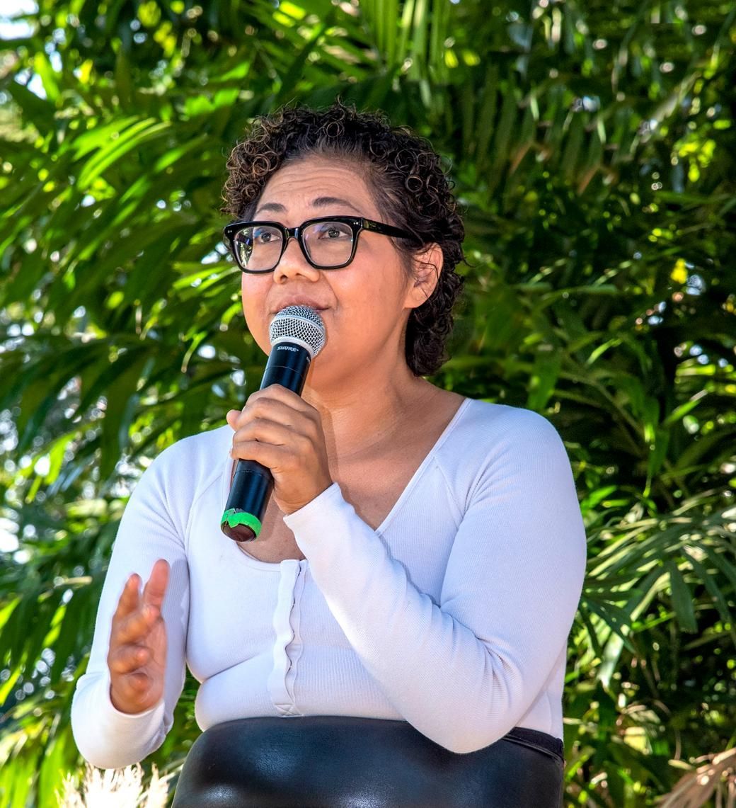 A Woman Wearing Glasses is Speaking into a Microphone — Photography in Darwin, NT