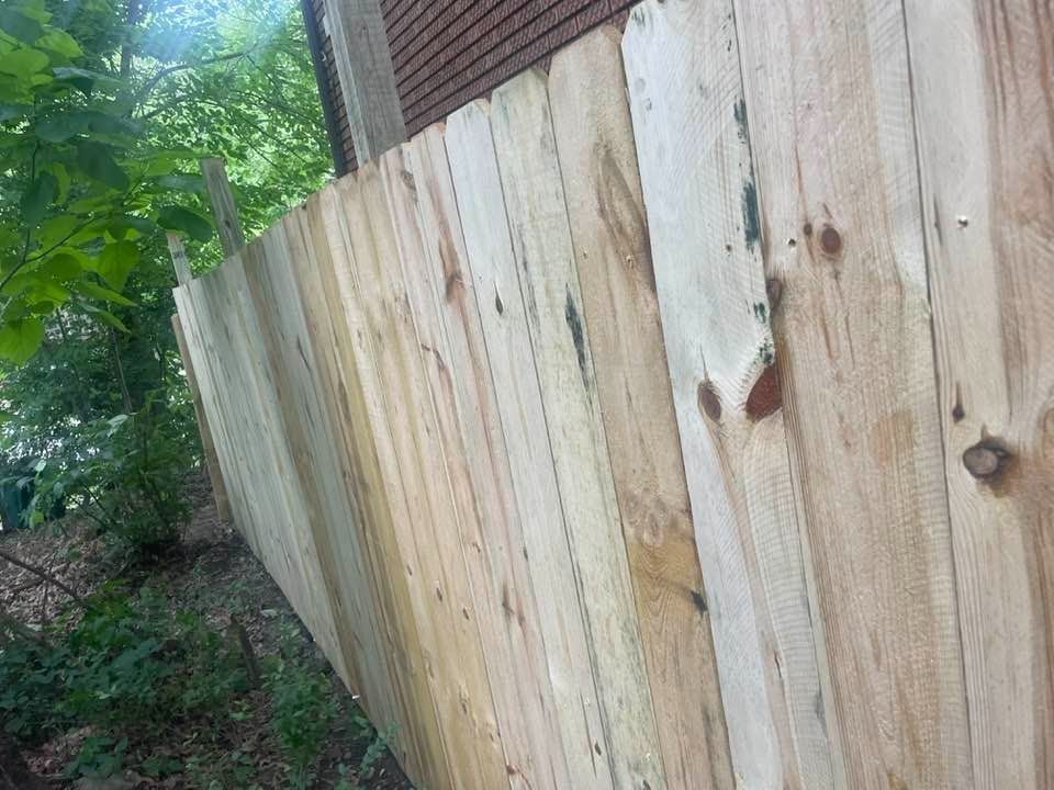 Wooden fence in a natural outdoor setting, with varying wood tones and knots.
