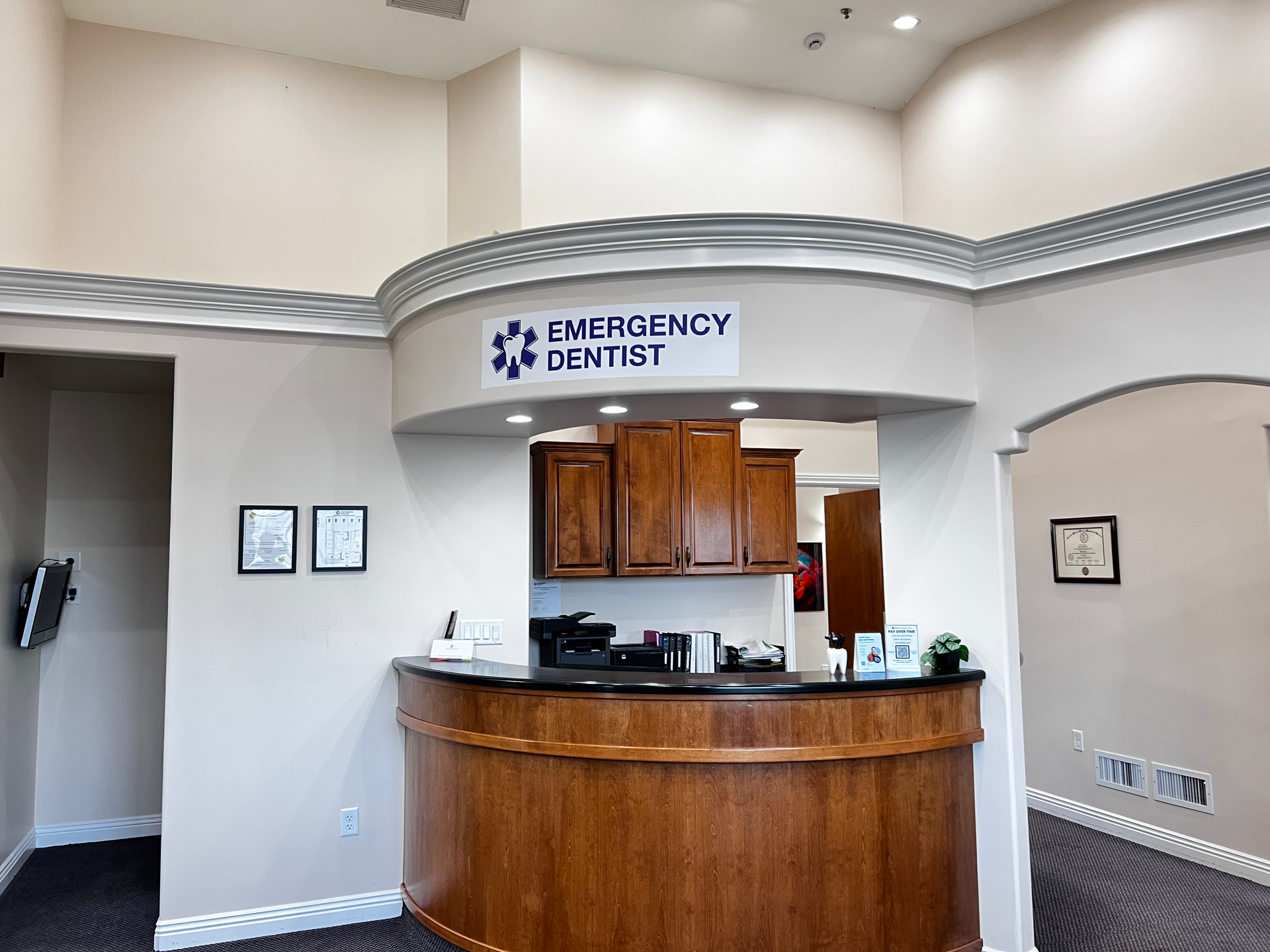 Reception desk at a dental office with a wooden counter and a sign reading 