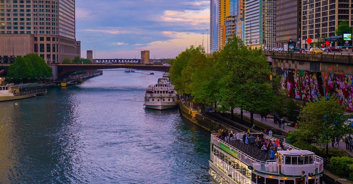 A group of boats are floating down a river in a city.