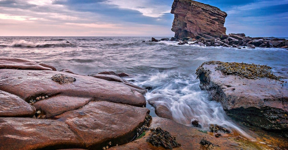 There is a large rock in the middle of the ocean.