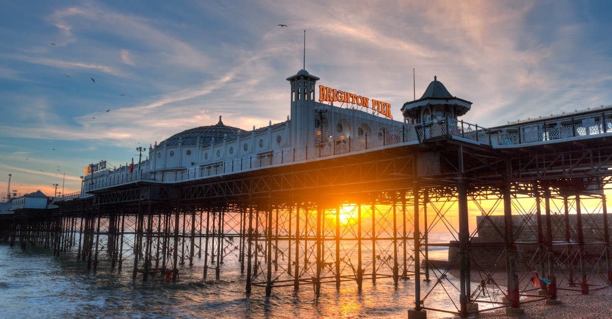 The sun is setting behind the brighton pier.