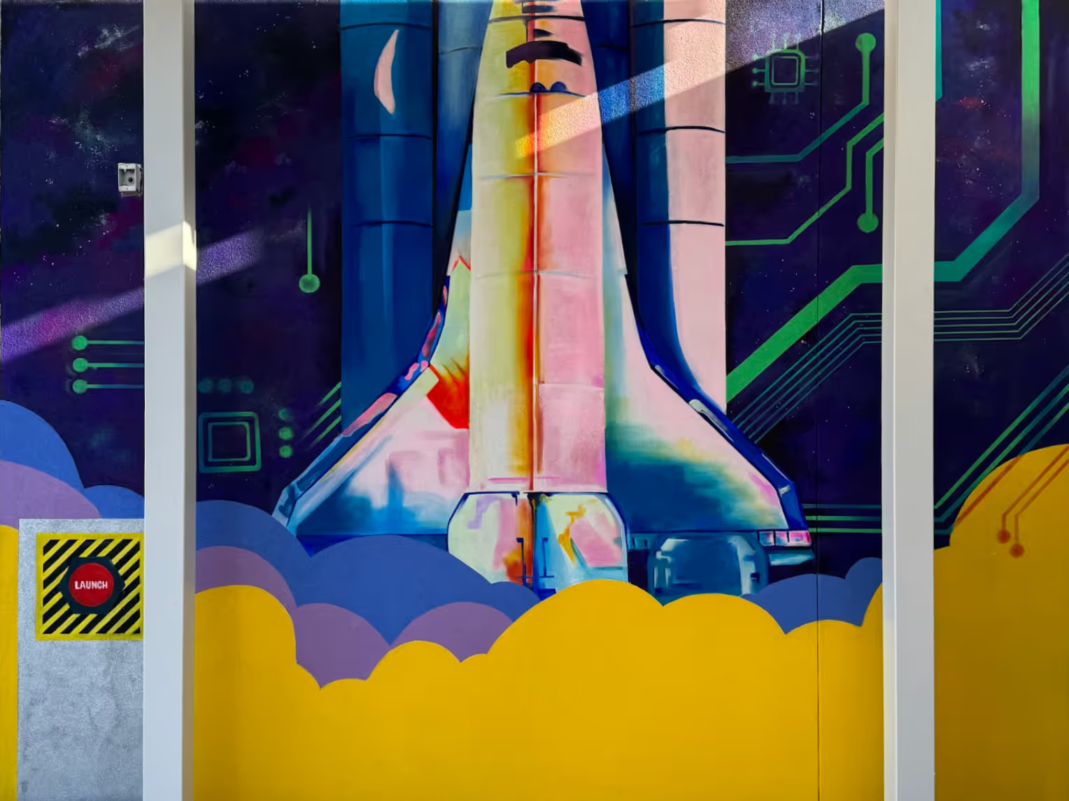 Space shuttle mural with circuit board design in the background. Yellow, blue, and purple colors dominate.