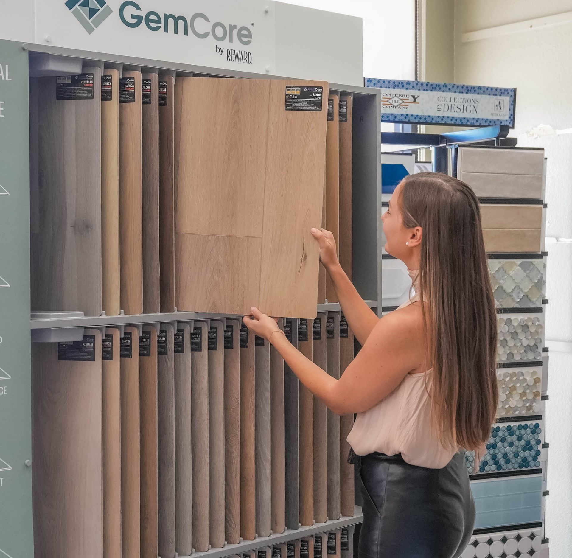 A woman is looking at a display of gemcore tiles