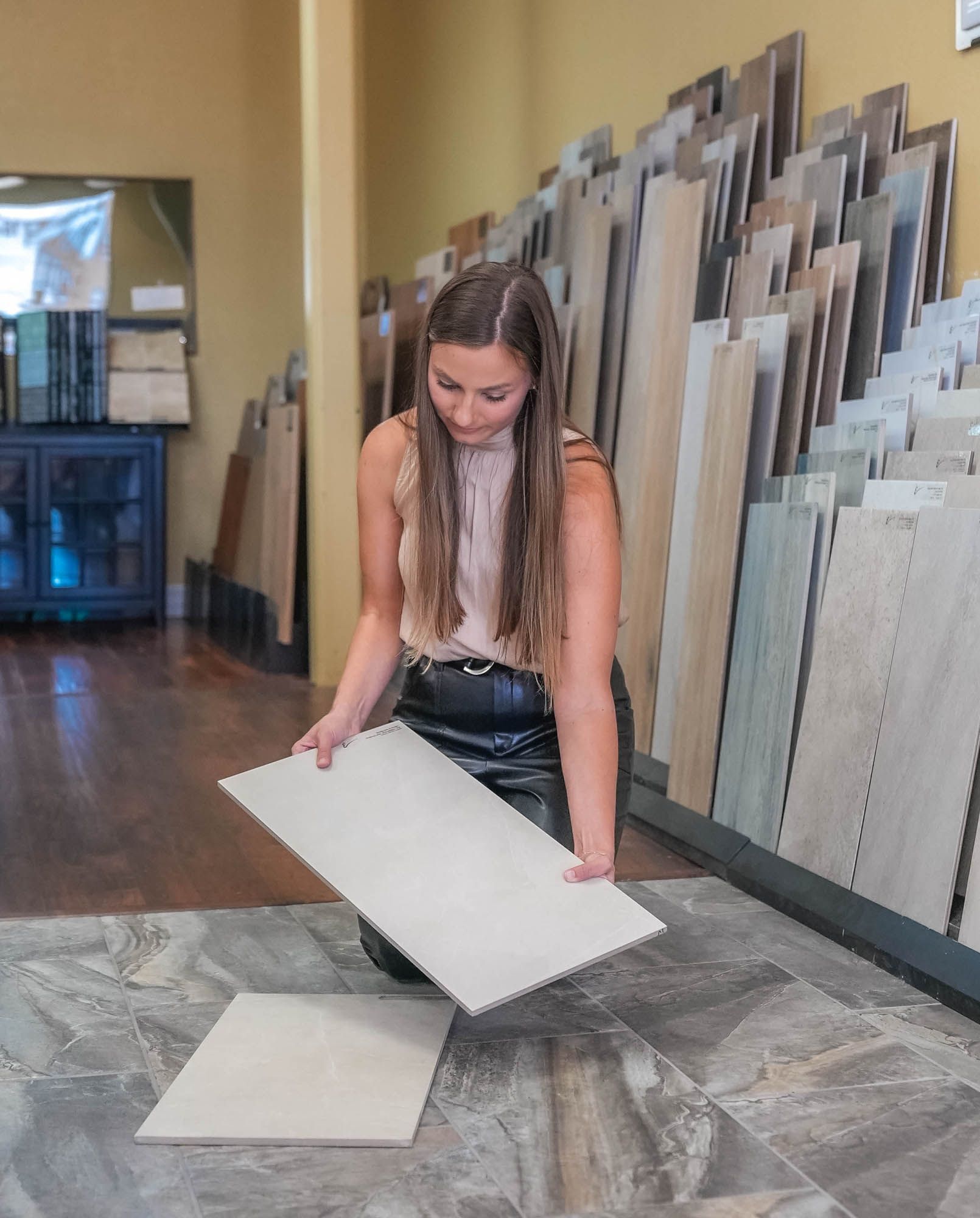 A woman is looking at tiles in a store.