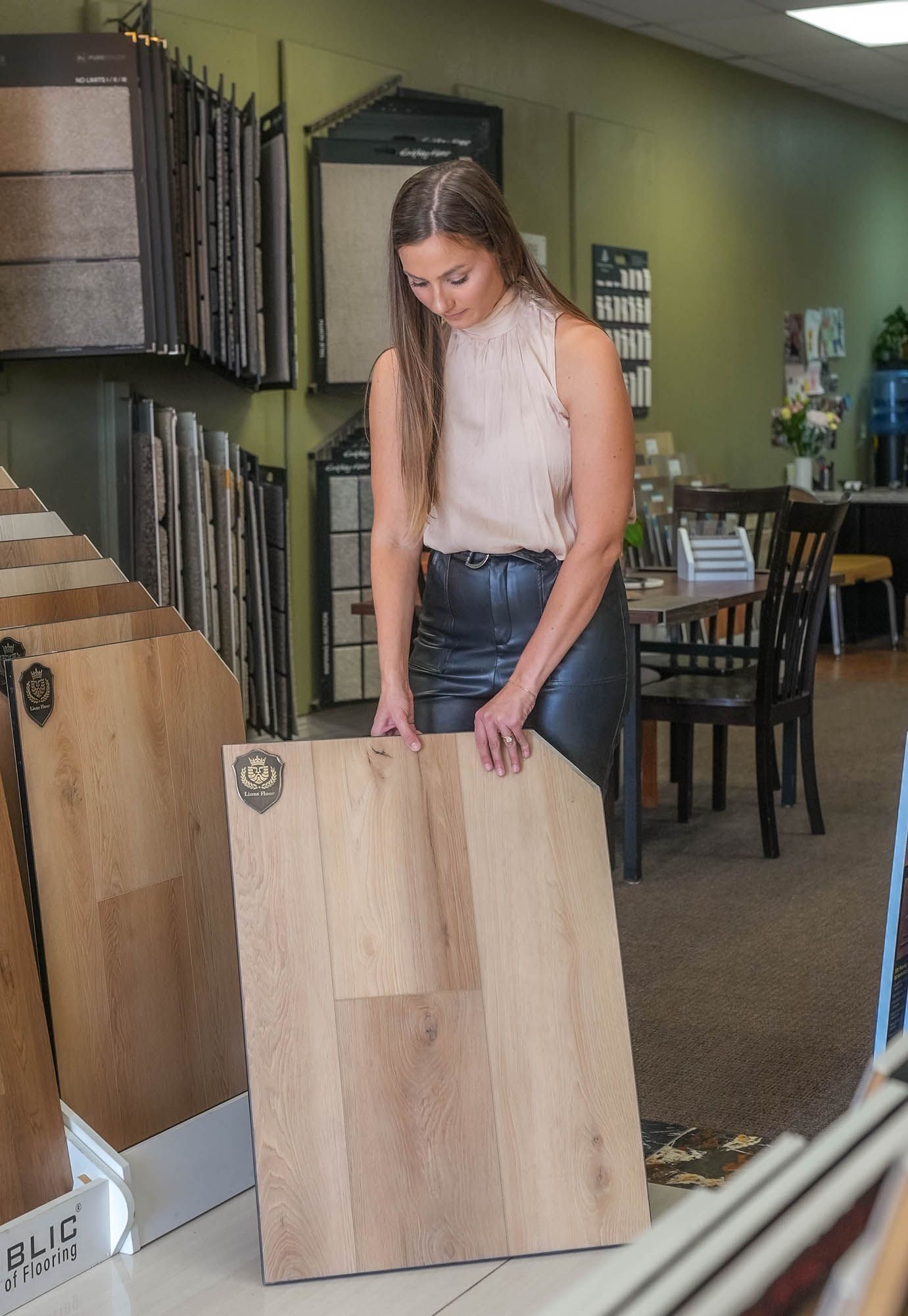 A woman is holding a piece of wood in a store.