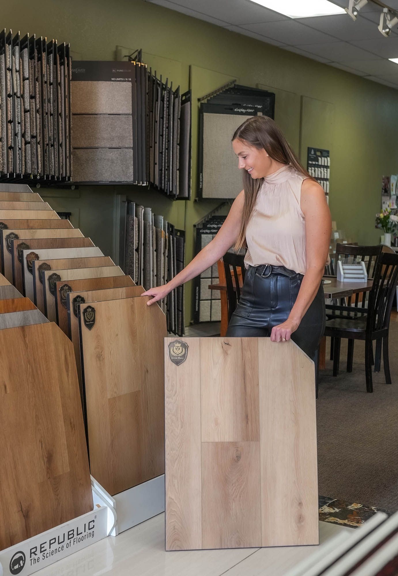 A woman is holding a piece of wood in a store.