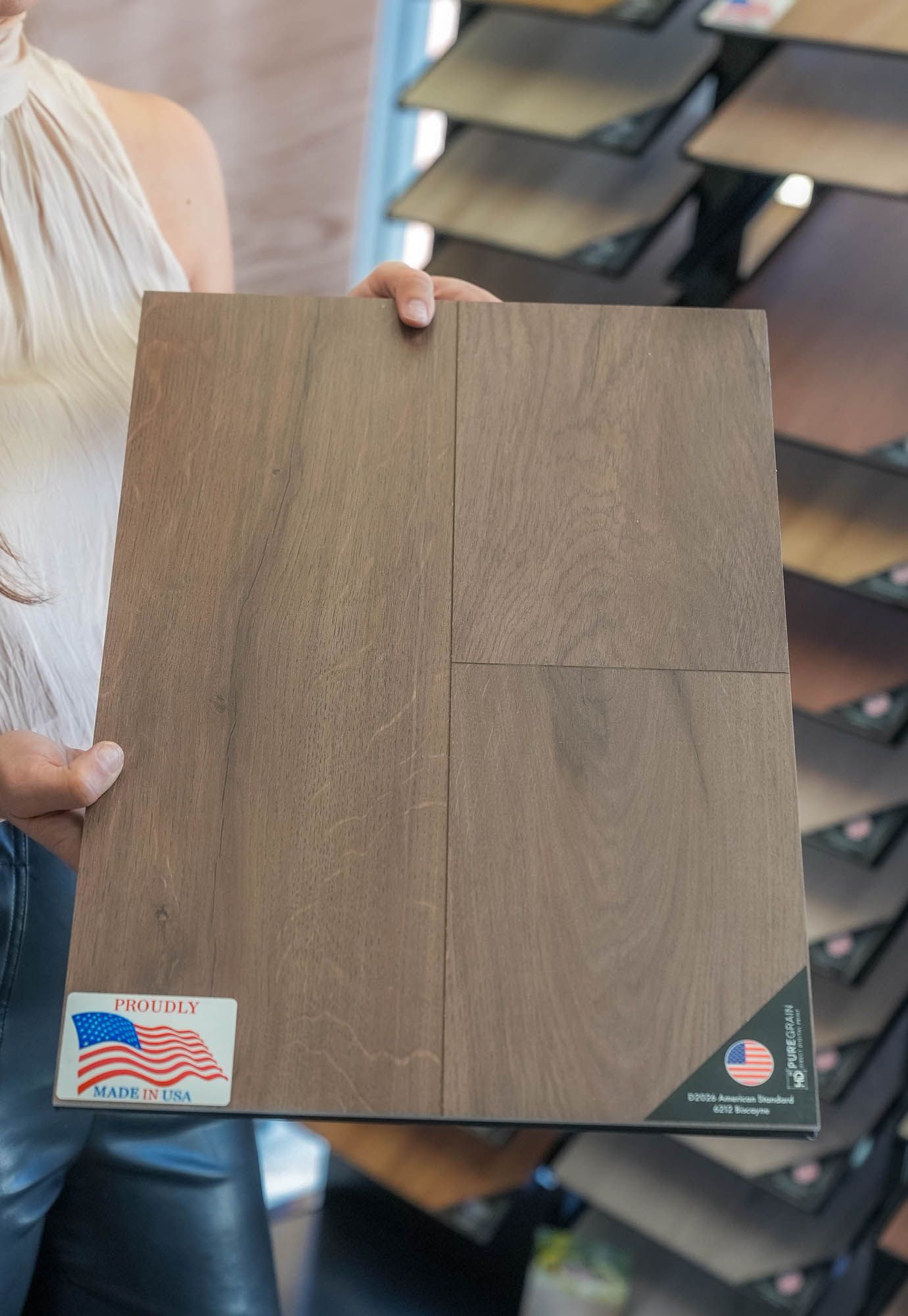 A woman is holding a piece of wood in her hands.