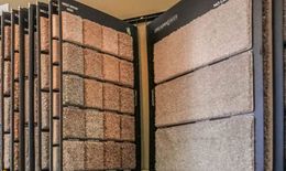 A display case filled with a variety of carpet samples.