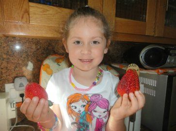 little girl holding strawberries