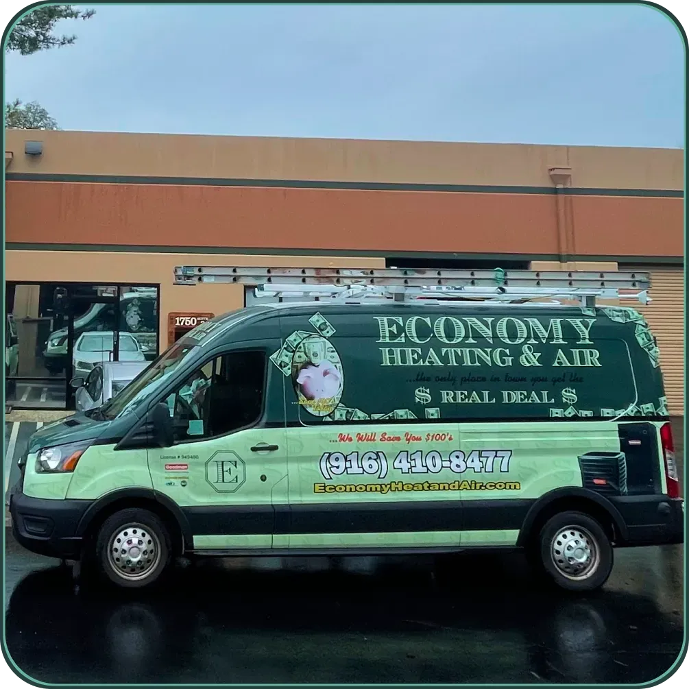 An economy heating and air van is parked in front of a building