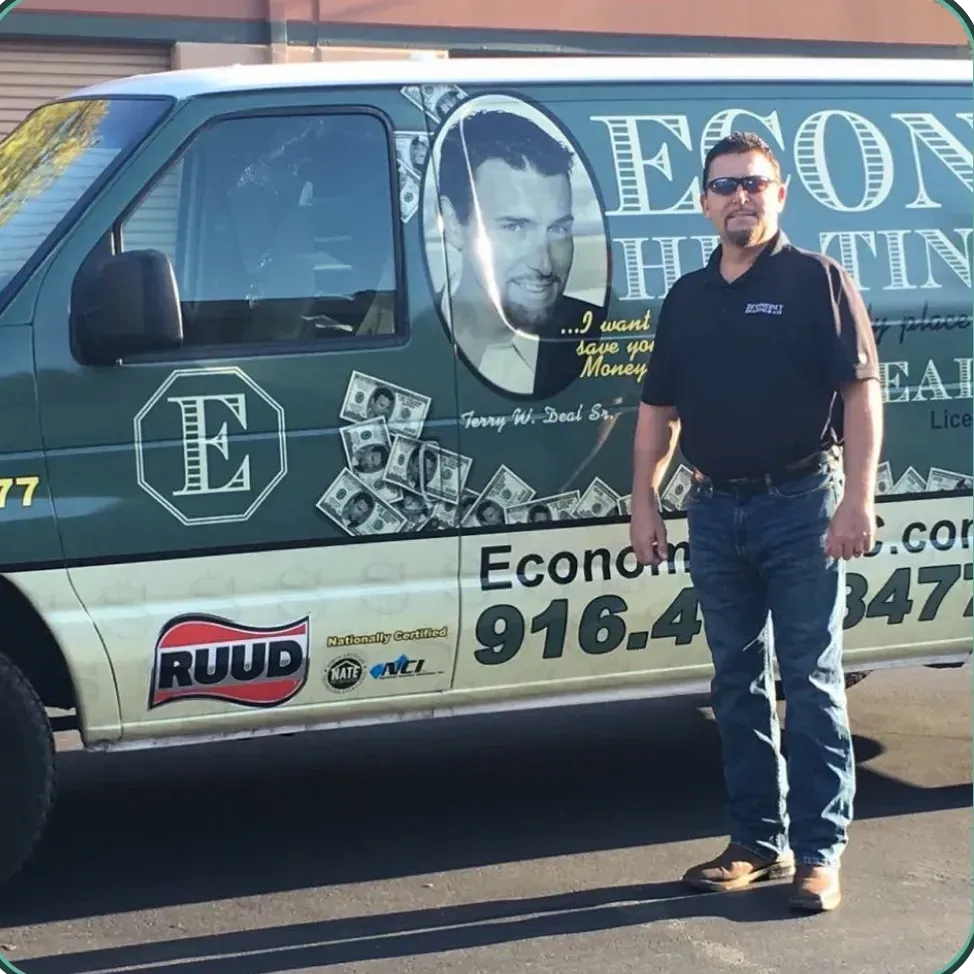 A man stands in front of a van that says econo