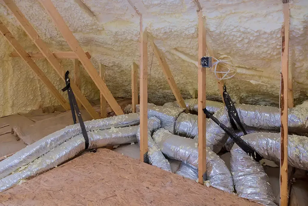 There are a lot of ducts in the attic of a house.