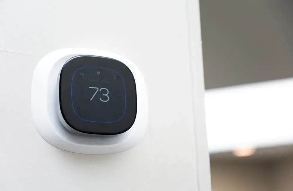 A black and white thermostat with the number 73 on it