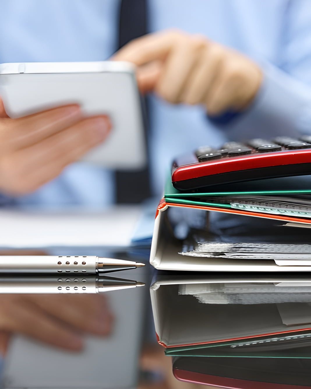 A Man is Using a Cell Phone Next to a Stack of Papers and a Calculator — AJA Bookkeeping Services In Cairns, QLD