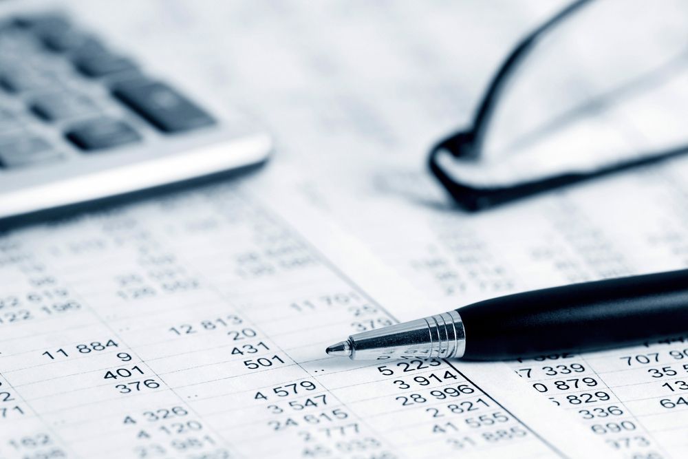 Calculator, Eyeglasses, and Pen on a Document With Financial Data — AJA Bookkeeping Services In Cloncurry, QLD