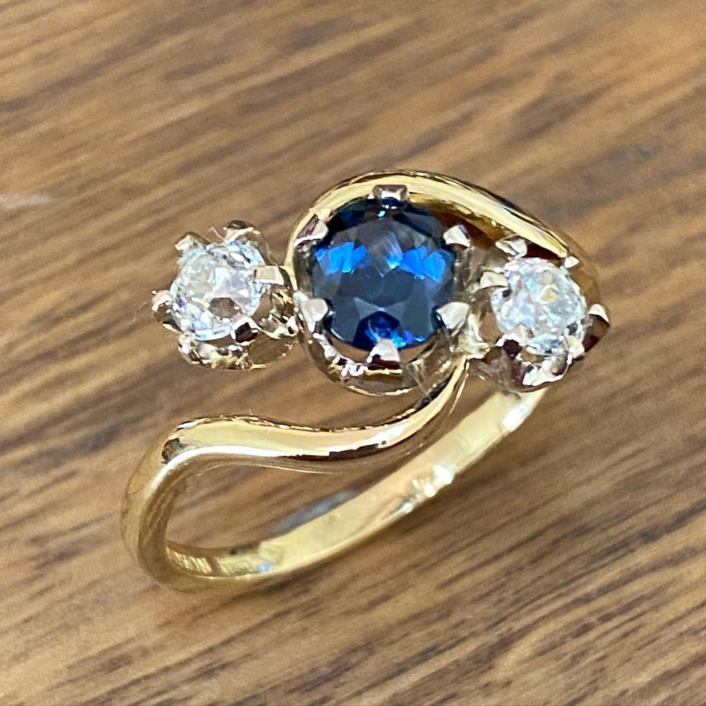 Gold ring with a dark blue center stone and two white side stones. — Burchell's Jewellers In Bowral, NSW