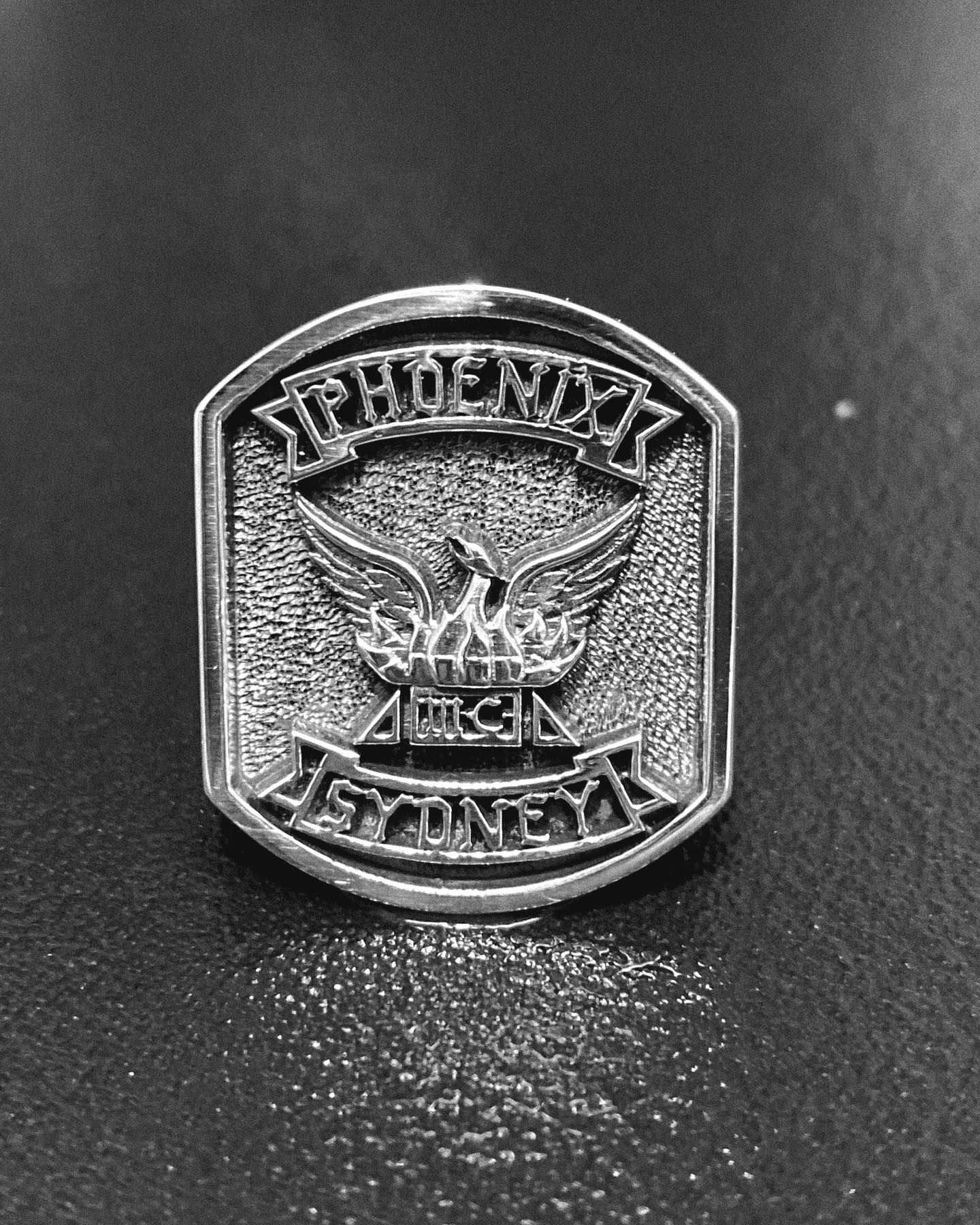 A metal pin shaped like a shield, featuring an eagle emblem — Burchell's Jewellers In Bowral, NSW