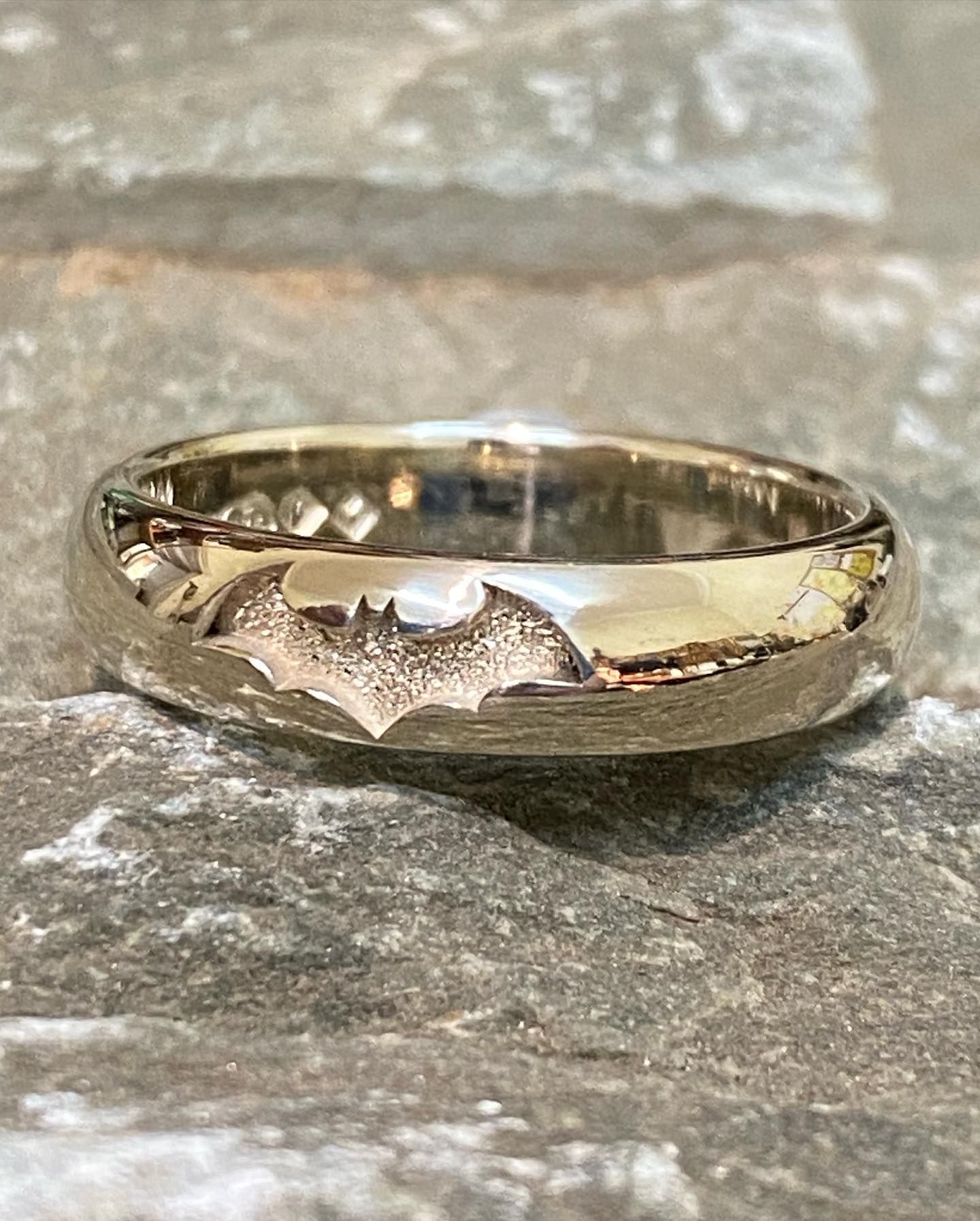 Silver Ring With Batman Symbol Engraved On A Stone Surface — Burchell's Jewellers In Bowral, NSW