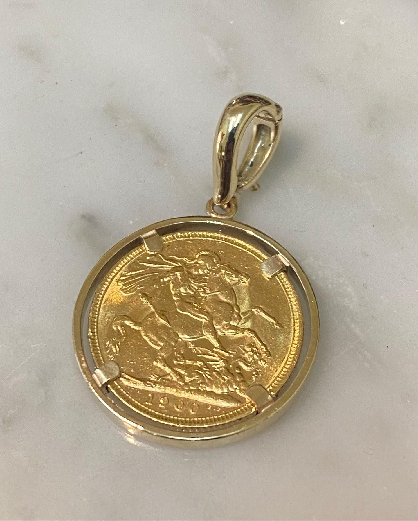 Gold Ring With a Blue Gemstone and Two White Gemstones Set on a Wooden Surface — Burchell's Jewellers In Bowral, NSW