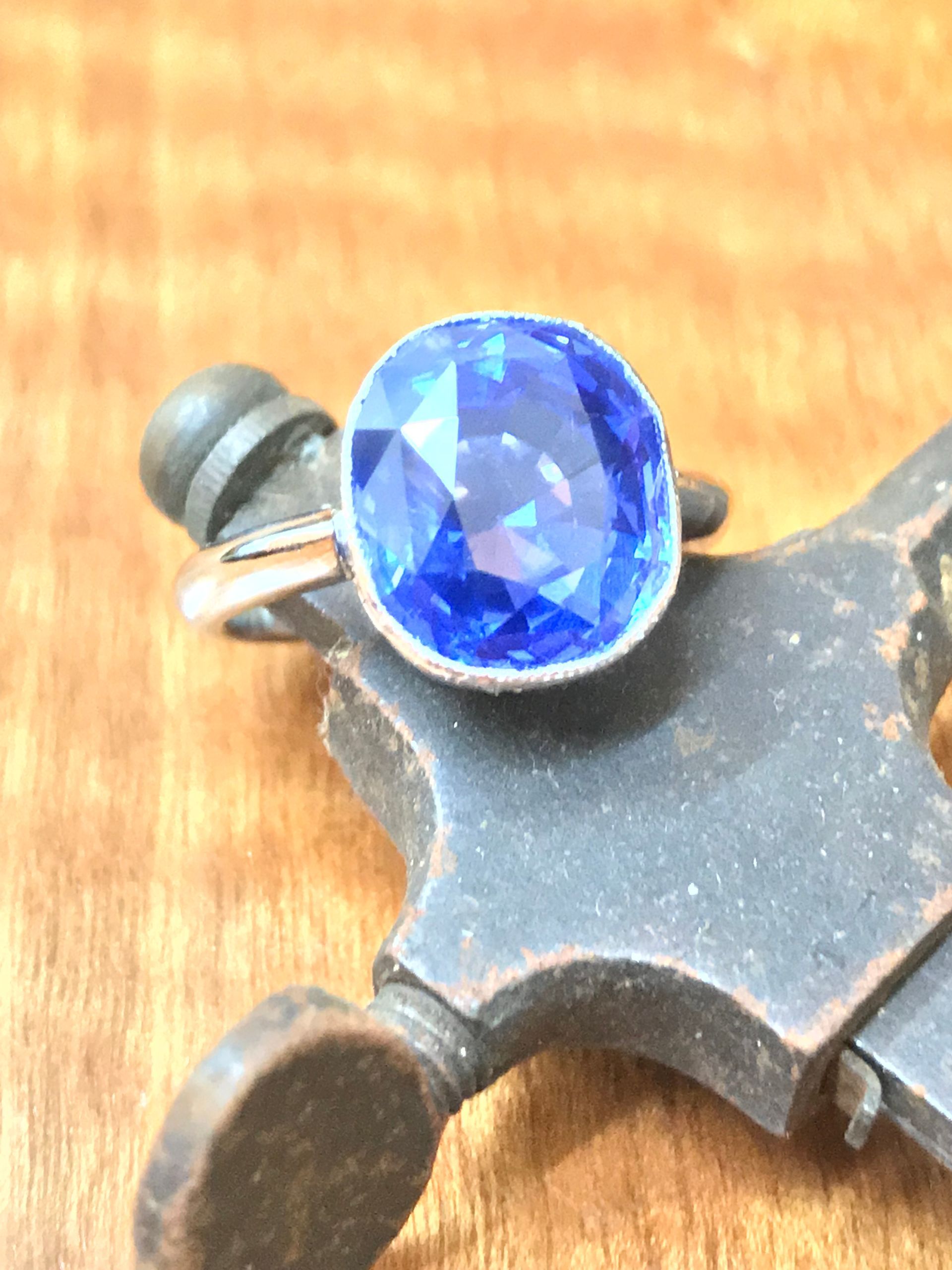 Blue Sapphire Ring Resting on an Old, Metallic Object — Burchell's Jewellers In Bowral, NSW