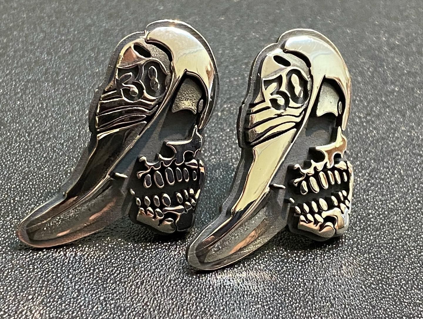 Two metallic skull-shaped lapel pins — Burchell's Jewellers In Bowral, NSW