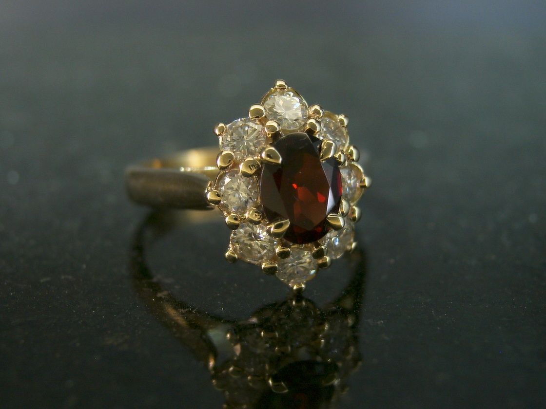 Gold Ring With a Garnet Center Stone, Surrounded by Diamond Accents — Burchell's Jewellers In Bowral, NSW