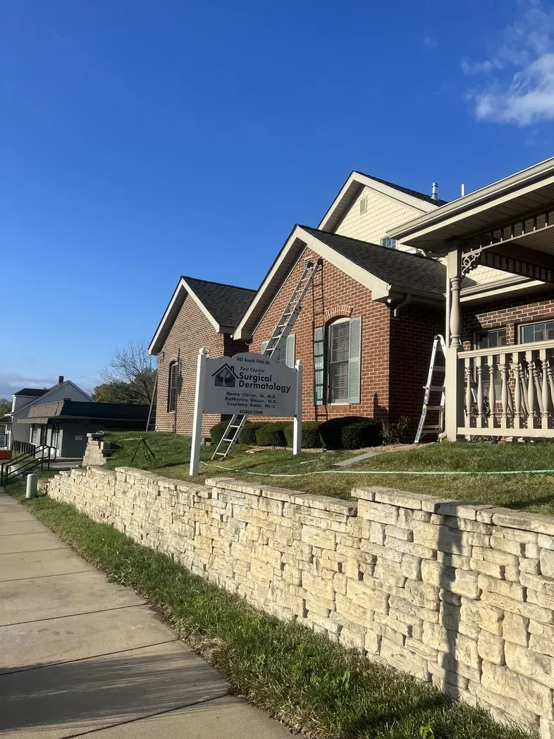 A brick house with a front sign for 