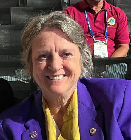 A woman standing in front of an american flag and a puzzle
