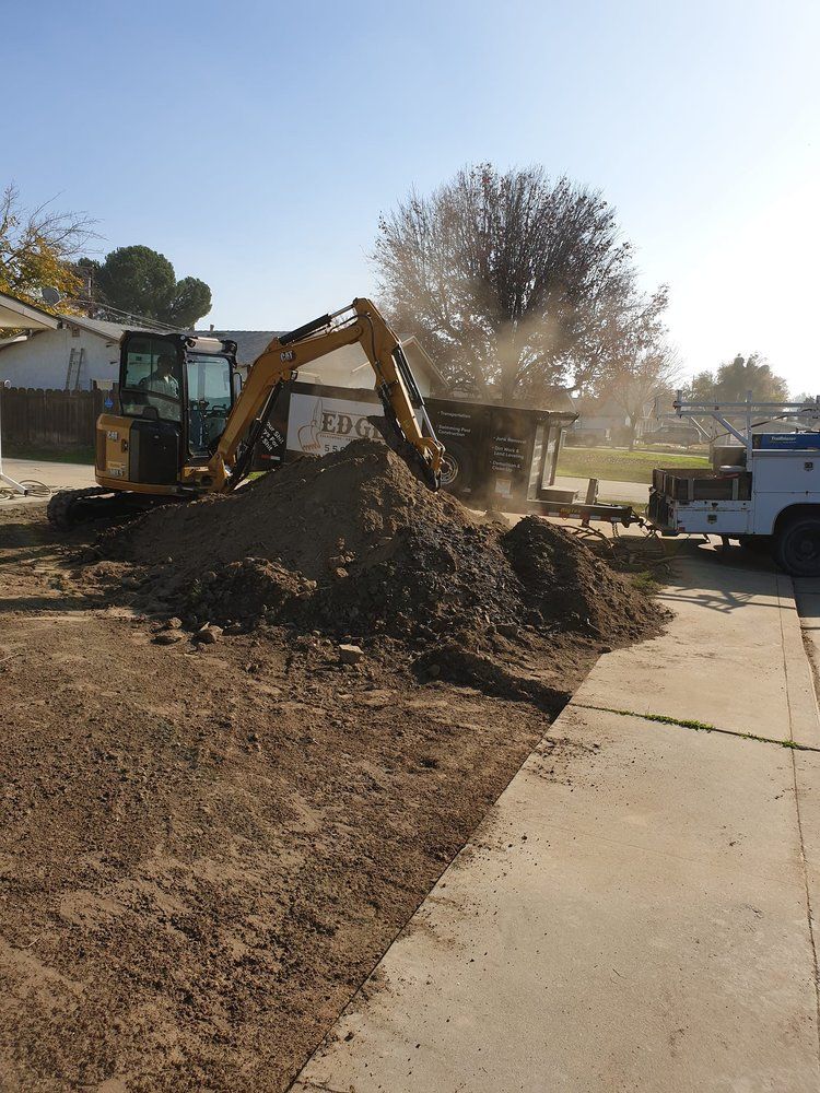 A large pile of dirt is being moved by an excavator