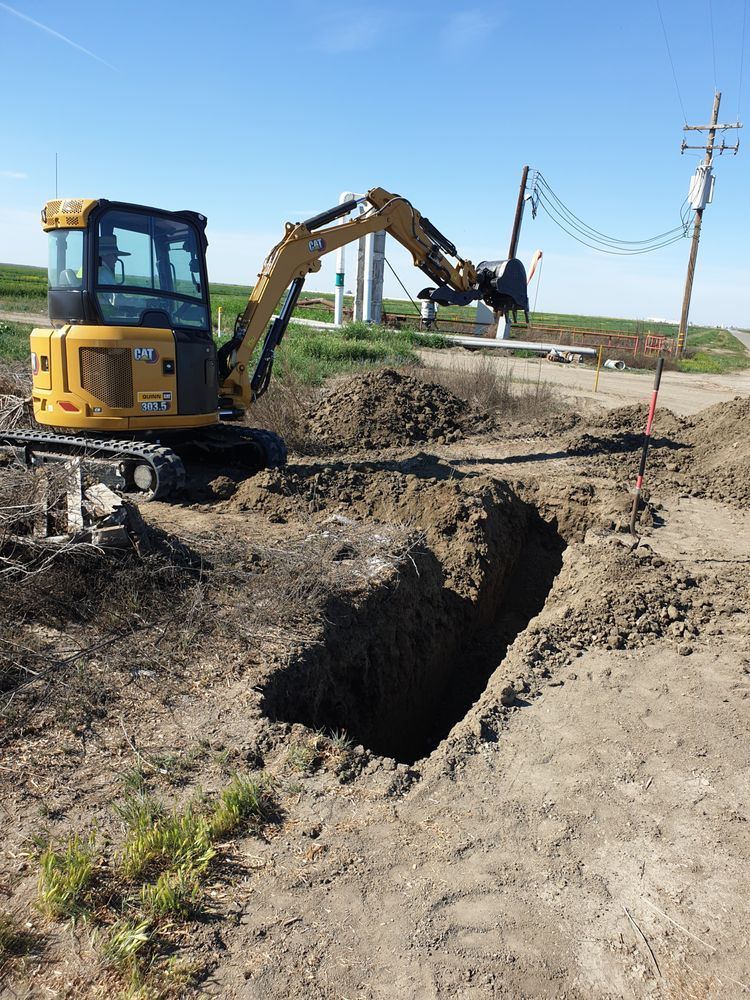 A yellow excavator is digging a hole in the dirt.