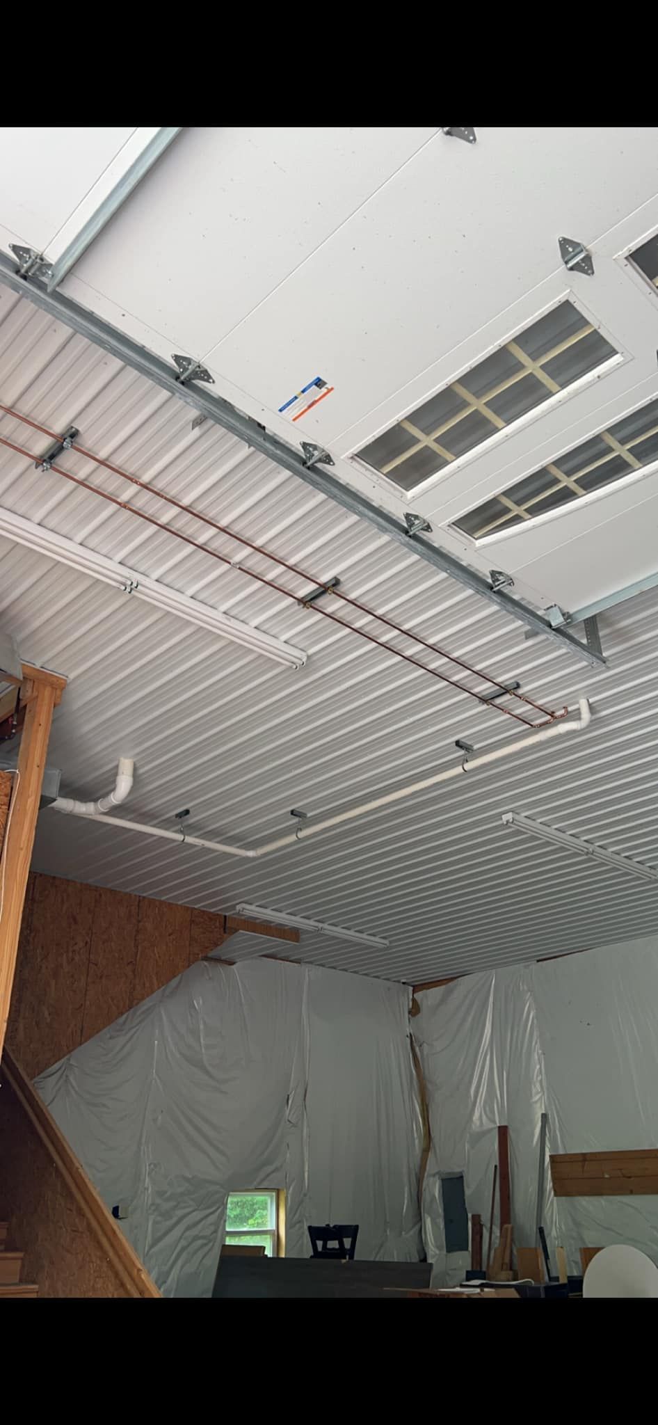 A garage with a staircase and a garage door open.