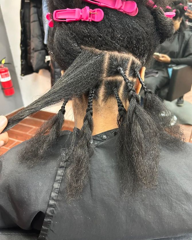 a woman is getting her hair braided in a salon .